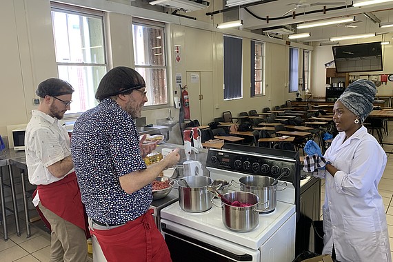 Kochen in der DUT Durban mmit zwei Professoren und einer Professorin an einem Herd in einem Hörsaal