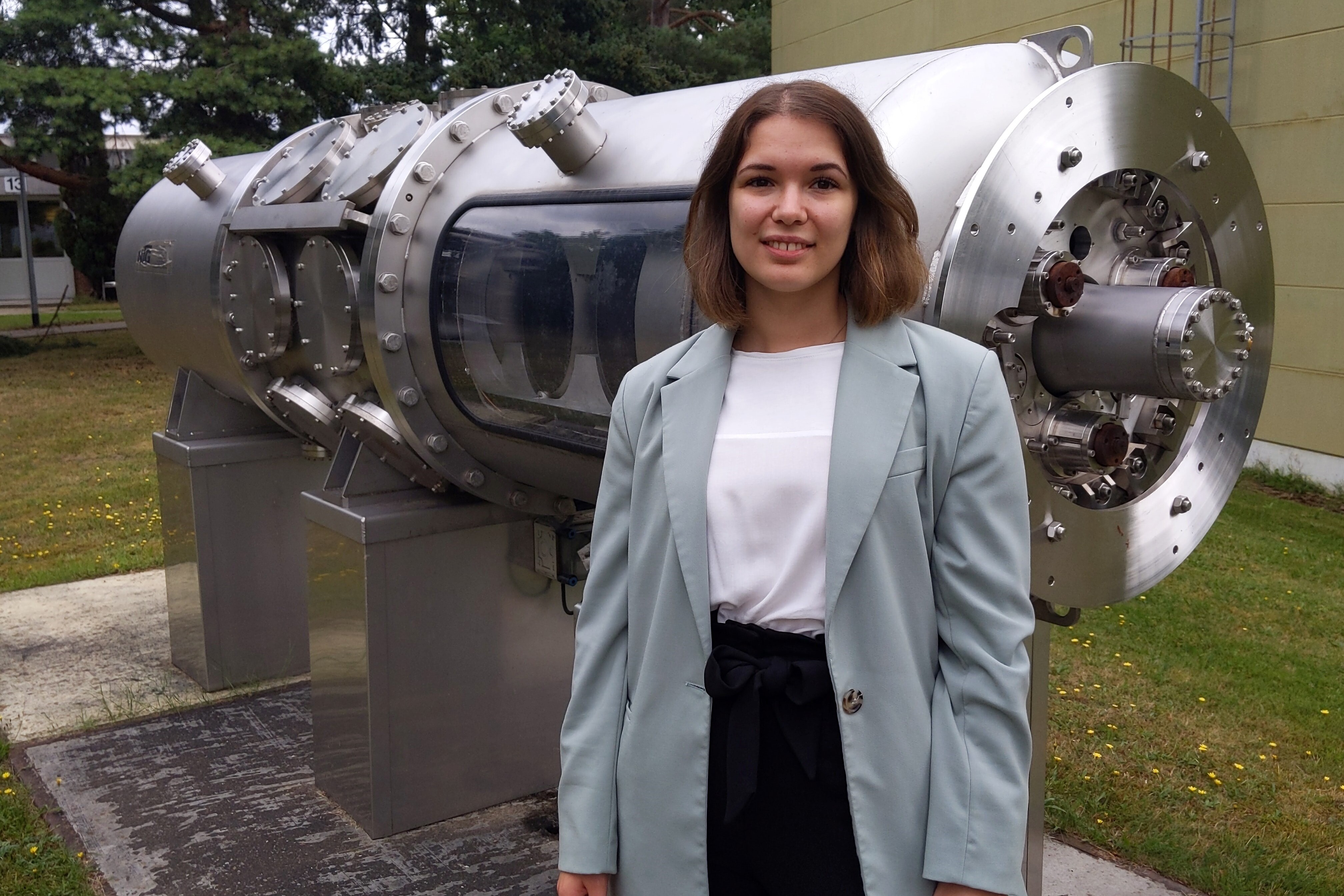 Marie-Charlott Kuse auf dem DESY-Gelände steht vor der Einheit zur supraleitende Teilchenbeschleunigung. Copyright Yvonne Scheller / HAW Hamburg