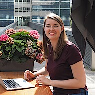 Female student sitting with a laptop outside on campus