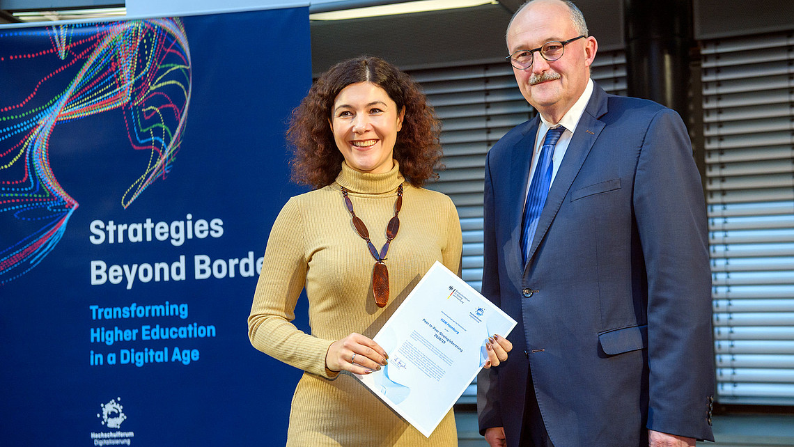 Das Bild zeigt die Vizepräsidentin für Digitalisierung der HAW Hamburg, Prof. Dr. Olga Burkova, mit Michael Meister, dem parlamentarischen Staatssekretär beim Bundesministerin für Bildung und Forschung (BMBF) bei der Übergabe der Urkunde für die erfolgreiche Teilnahme der Hochschule an der P2P-Strategieberatung.